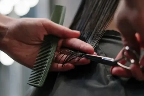 imagem de cabelereiro cortando cabelo de mulher